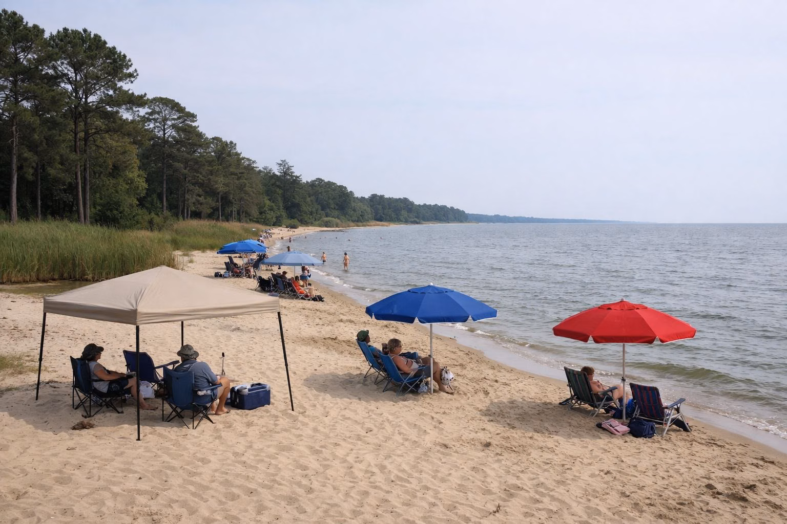 Small open-sided sun shades and umbrellas spaced out on a sandy beach, people relaxing, no tents